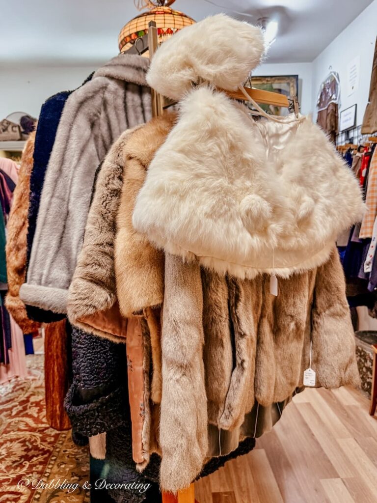 Women's mink stalls and coats hanging in antique store in Saratoga Springs, NY Stone Soup Antiques.