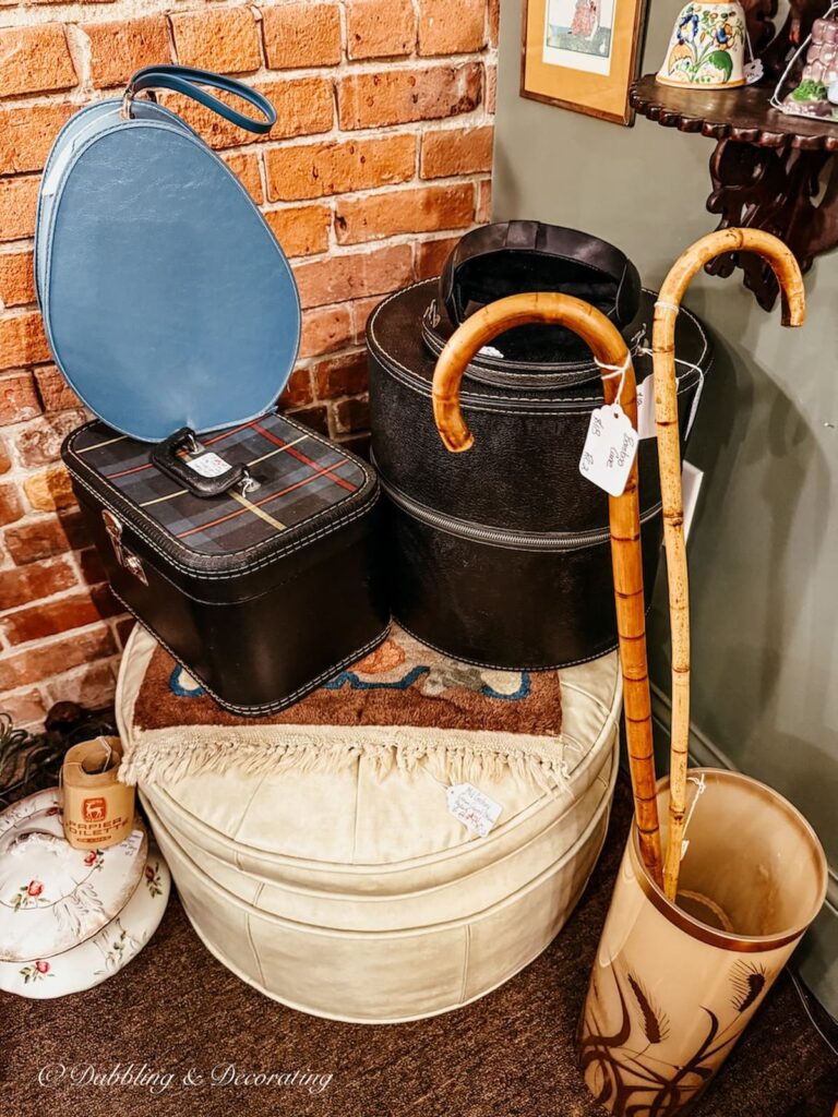 Small luggage pieces and wooden canes gathered in a corner while antiquing in Saratoga Springs.