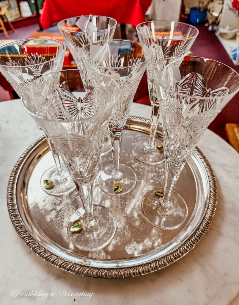 Set of Irish Waterford glasses on silver tray in antique store for St. Patrick's Day decor ideas.