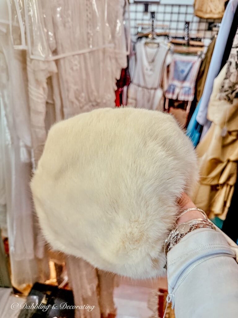 Vintage white fur muff in hand at Stone Soup's Antiques in Saratoga Springs, NY.