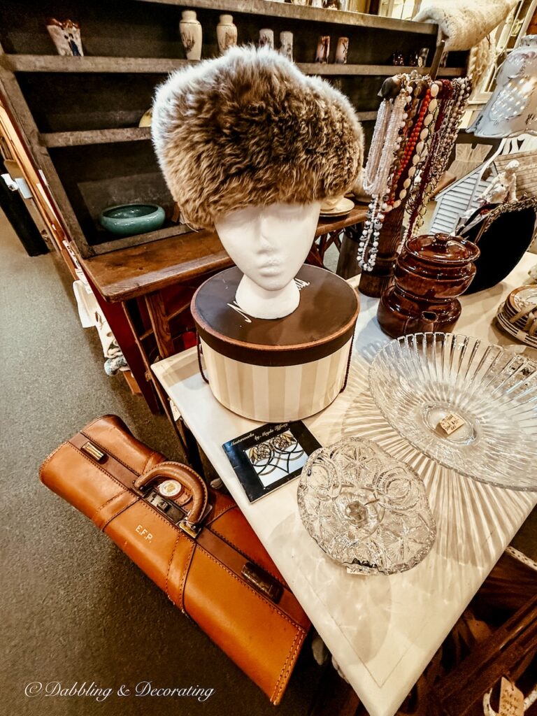 Leather luggage pieces and hat box with mannequin and fur hat antiquing in Saratoga Springs.