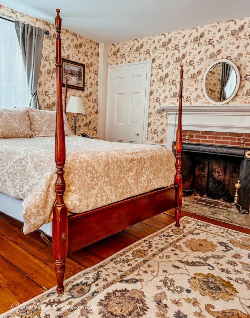 Bedroom wallpaper ideas inside the Quechee Inn Marshland Farm in Vermont with antique rug and four poster bed.
