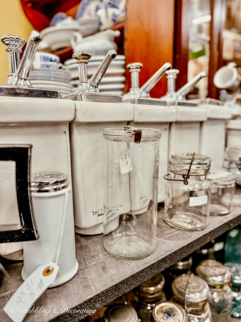 Set of white ironstone soda fountain containers on display at Eagle Bridge Antique Center.