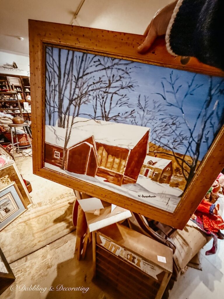 Vintage wooden painting of a Vermont barn in the snow in hand at Eagle Bridge Antiques in New York.