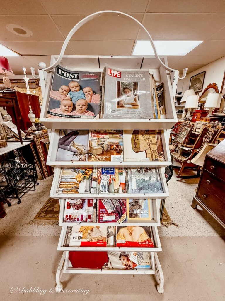 Antique white rack filled with vintage memorable headlined magazines in Eagle Bridge Antique Center in New York.