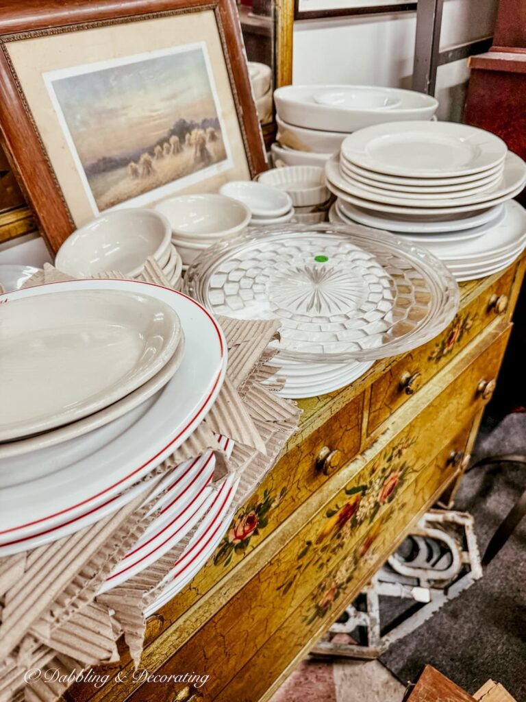 Antique dresser with stacked ironstone dishes and restaurantwares in Eagle Bridge Antique Center in New York.