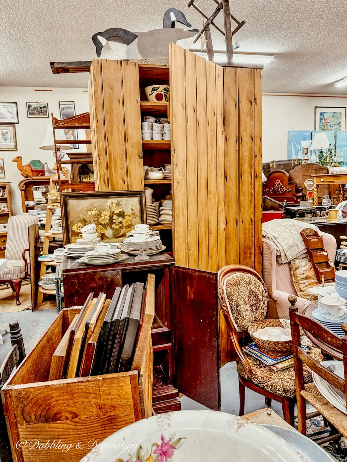 Antique pine cabinet filled with vintage dishes at Eagle Bridge Antiques in New York.