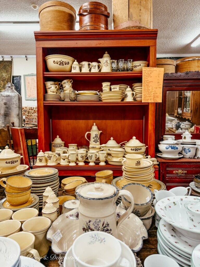 Antique hutch filled with vintage Phaltzgraff dishes in yellow in blue.