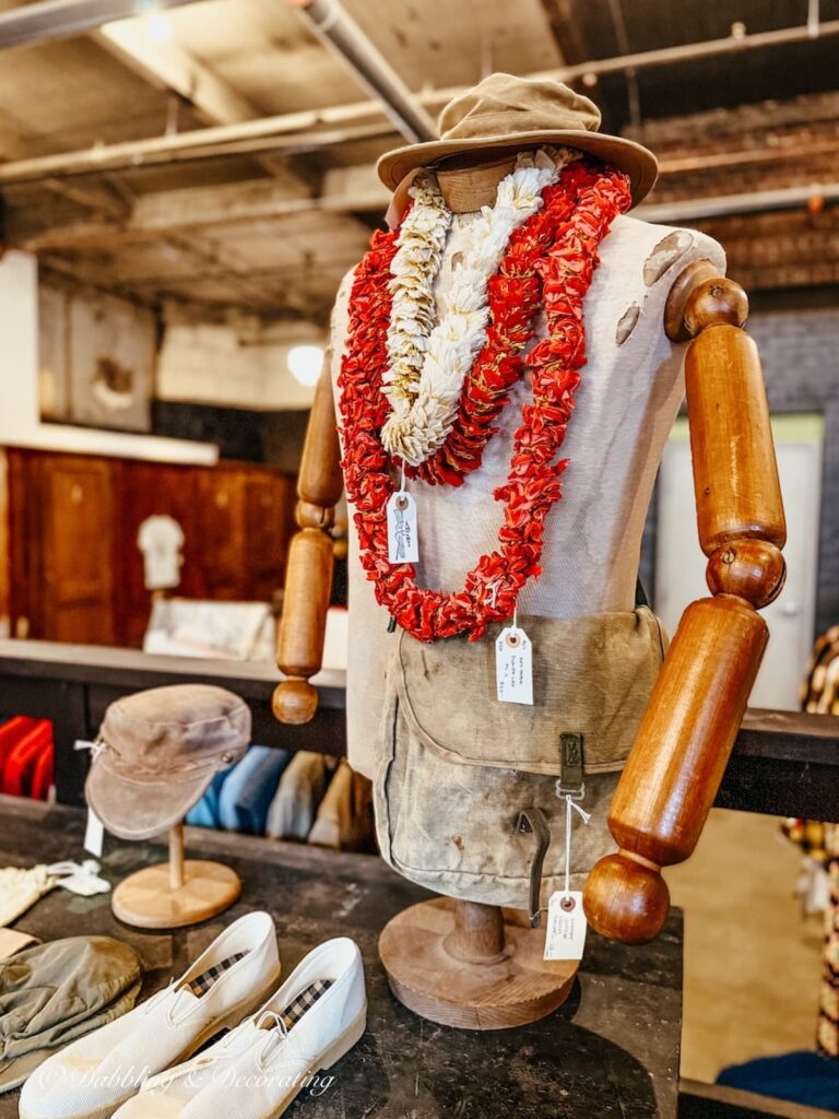 Antique wooden armed mannequin with Hawaiian leis inside the clothing section at Open House Portland, Maine.