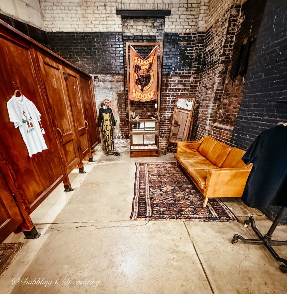 Dressing room styled at the Open House Vintage store in Portland, Maine with leather couch and wooden stalls beautiful details.