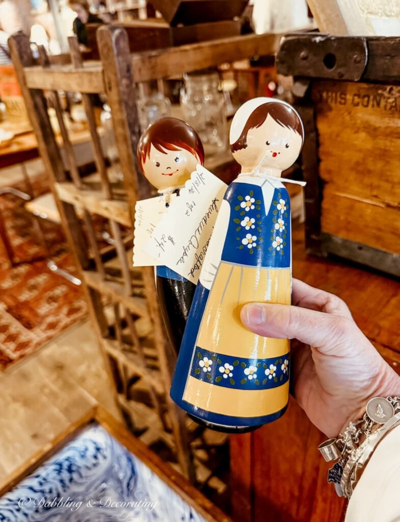 Two Scandinavian wall decor figurines; a man and woman in hand at an antique store in Portland, maine.