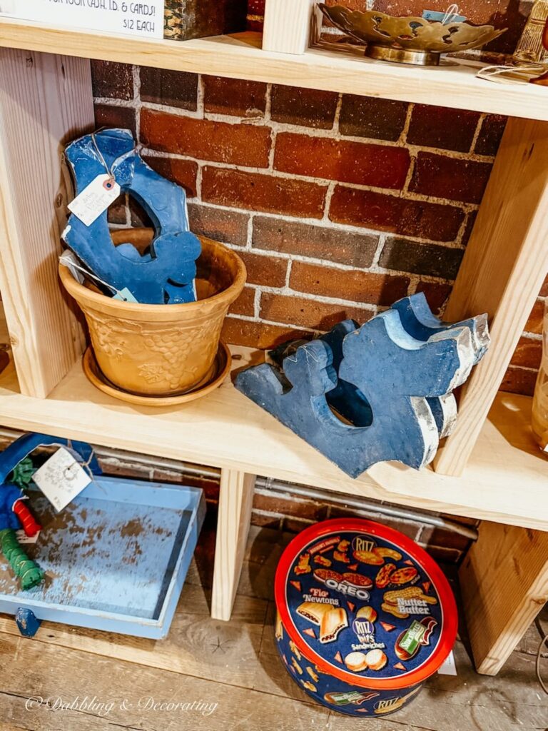 Two pairs of blue corbels; architectural salvage pieces on bookshelves at antique store.