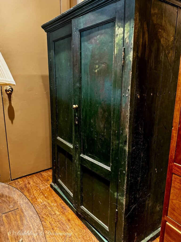 Green antique cabinet with two doors in antique store while looking for a cabinet for a Scullery-Inspired Kitchen Workroom in an open floor plan.