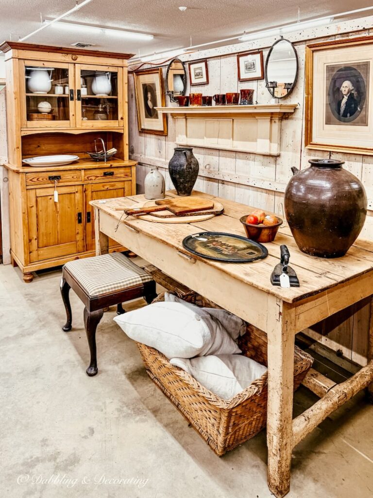 Vintage booth display at Stone House Antique Center in Chester Vermont with neutral theme antique table and hutch styled beautifully.
