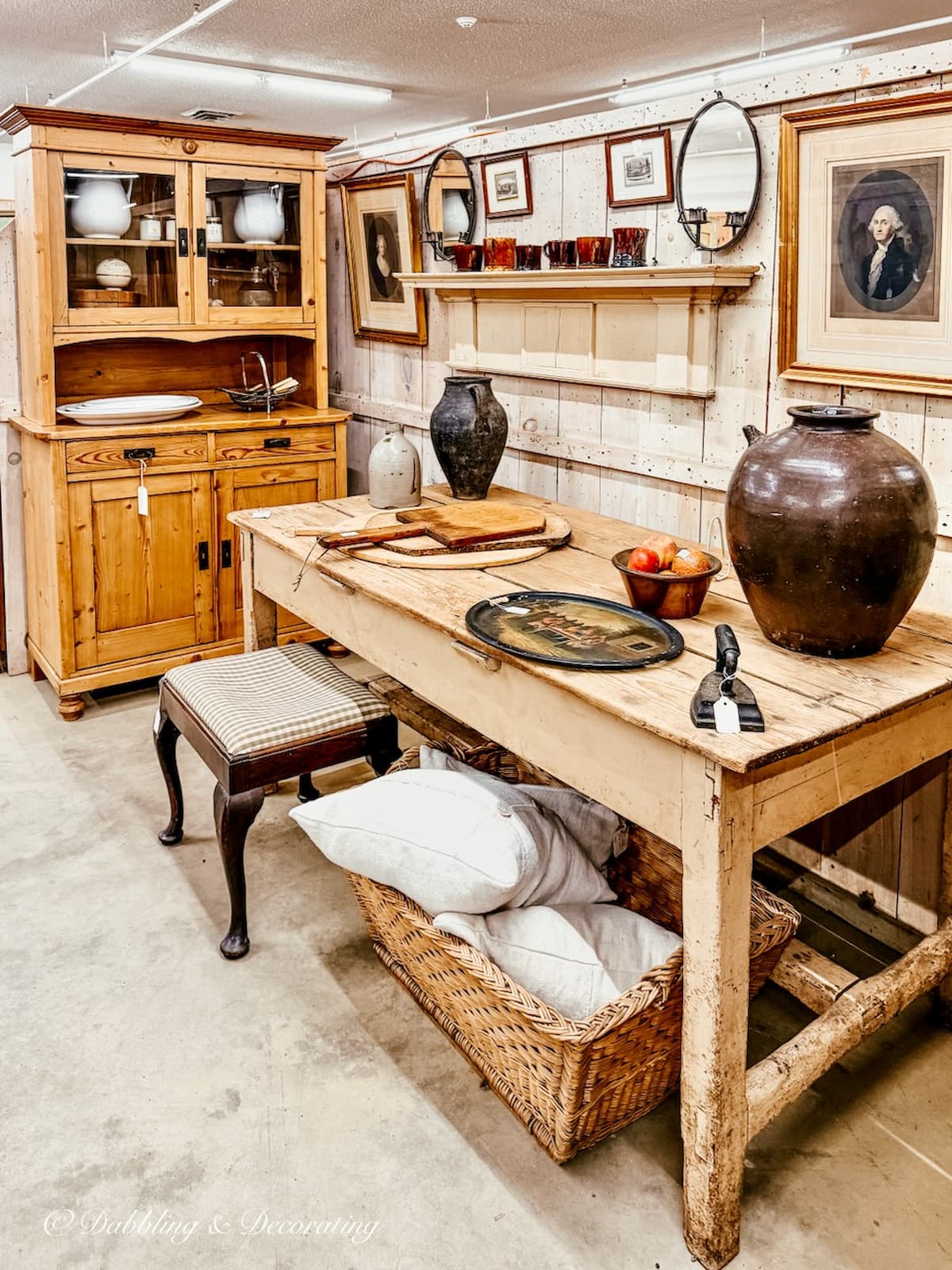 Vintage booth display at Stone House Antique Center in Chester Vermont with neutral theme antique table and hutch styled beautifully.