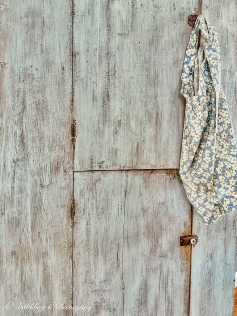 Blue antique cupboard close up with hanging apron.