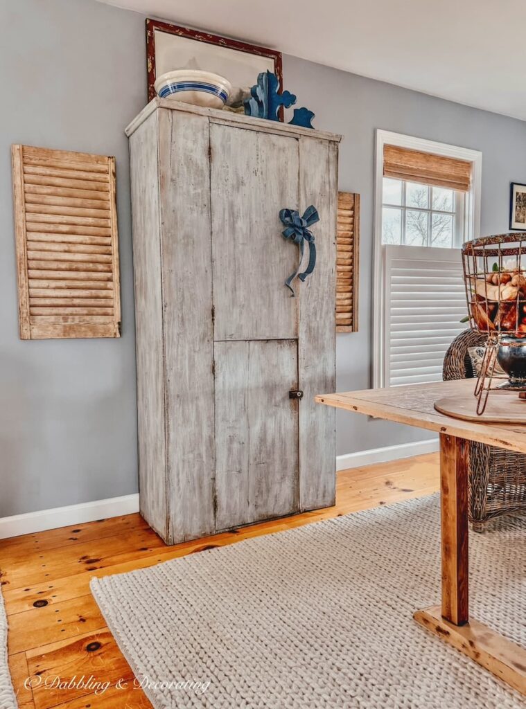 Blue Antique cupboard with closed storage on wall in open floor plan home off kitchen.