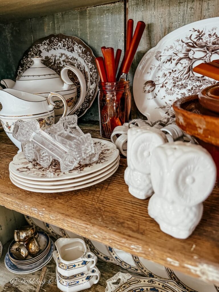 Antique cupboard shelf with vintage collections in brown and white.
