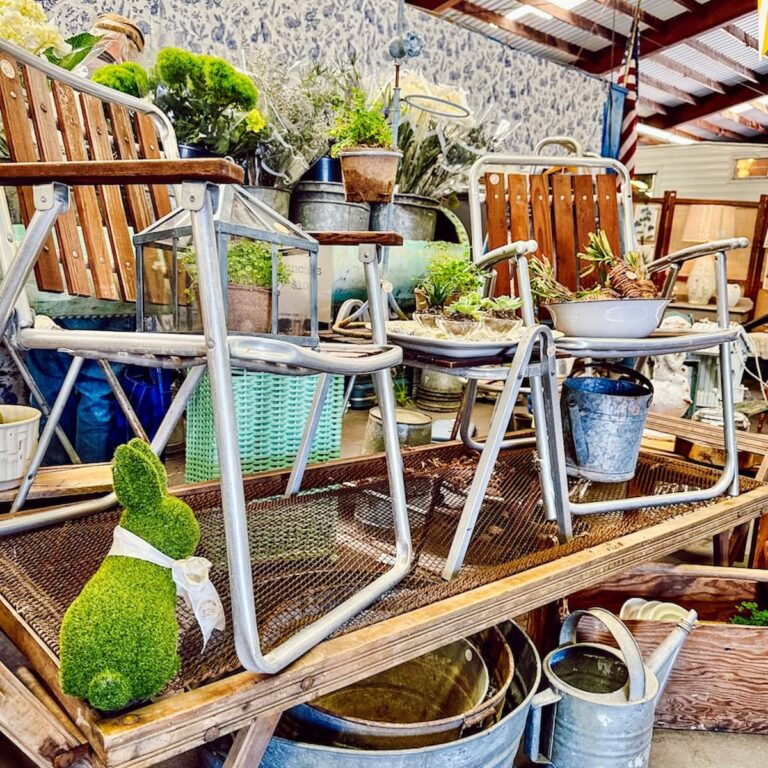 Vintage booth displays ideas for spring with lawn chairs and greenery stacked high at Vintage Market Days Vermont.