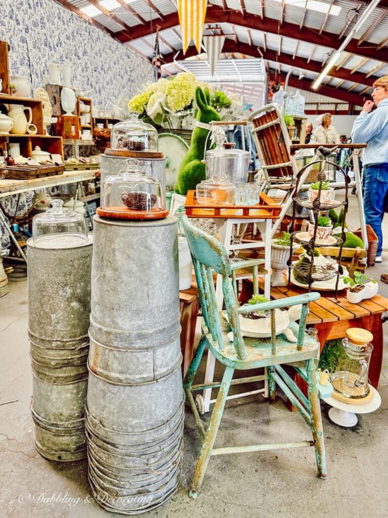 Vintage booth displays ideas at Vintage Market Days Vermont with beautiful spring greenery layered and stacked indoors.