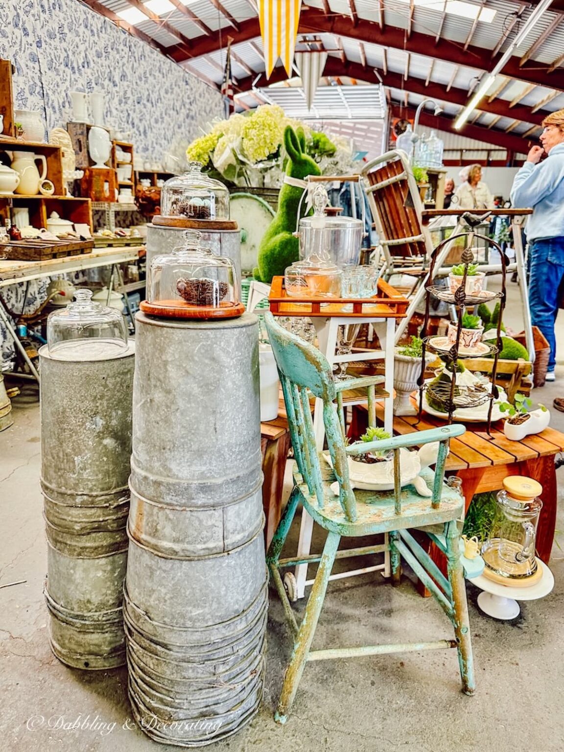 Vintage booth displays ideas at Vintage Market Days Vermont with beautiful spring greenery layered and stacked indoors.