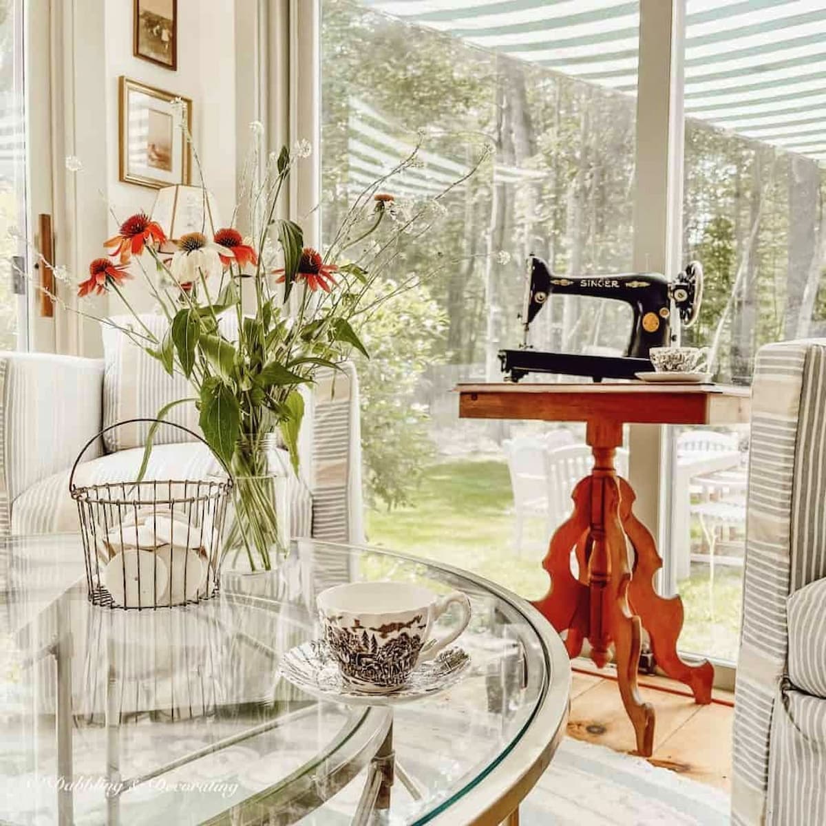 Thrift store decor finds, an antique wooden table with a vintage sewing machine displayed in sunroom.