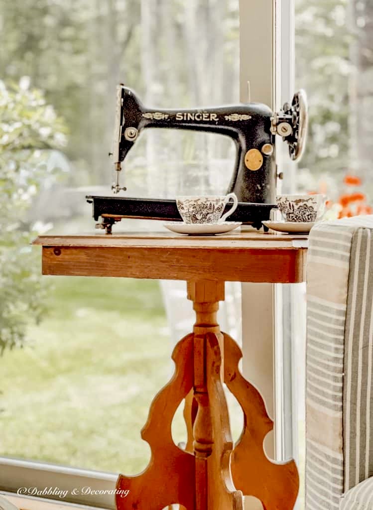 Old sewing machine, a black Singer on thrifted wooden vintage table in sunroom.