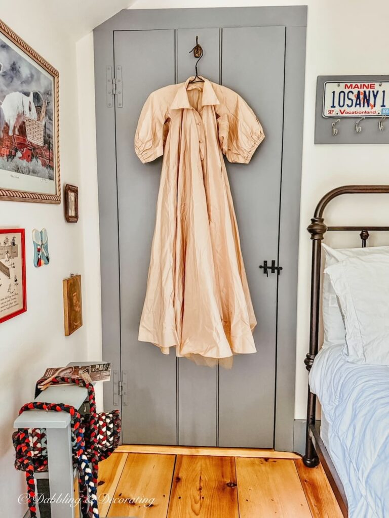 Thrifted beige petite antique taffeta gown hanging on bedroom door in coastal Maine home.