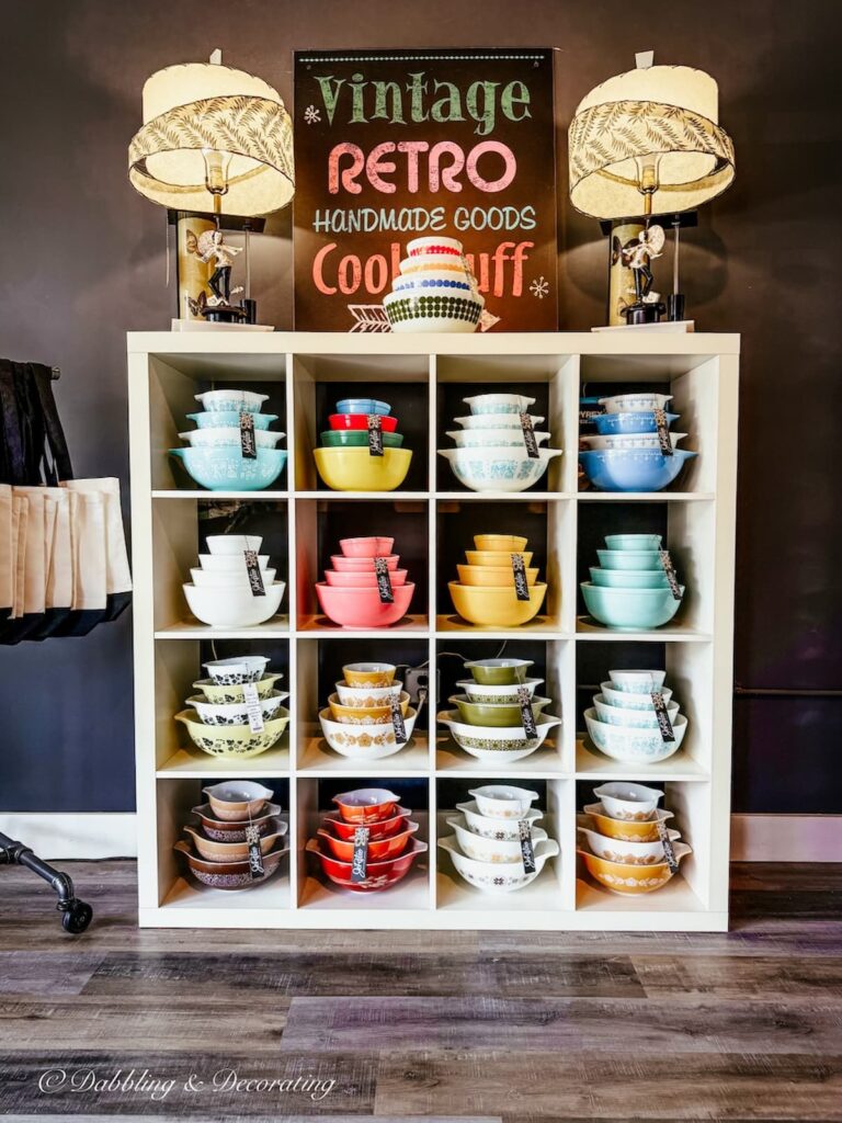 Shelving with stacks of vintage pyrex bowls inside RetroJo shop in Maryland.