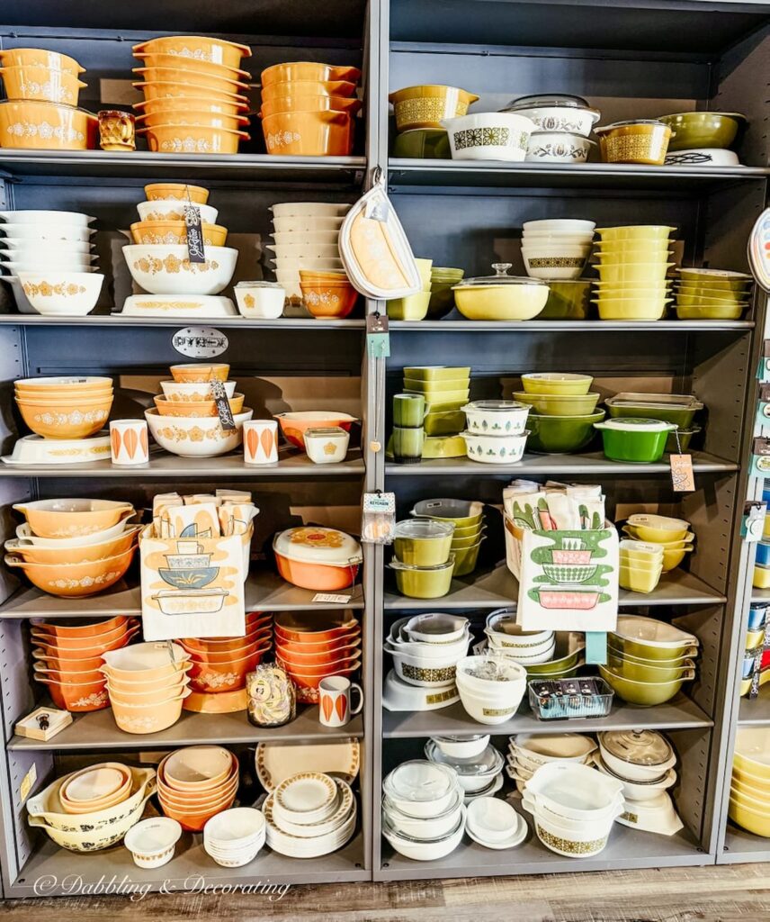 Two tall shelves filled with vintage Pyrex in green and orange antiquing in Maryland.