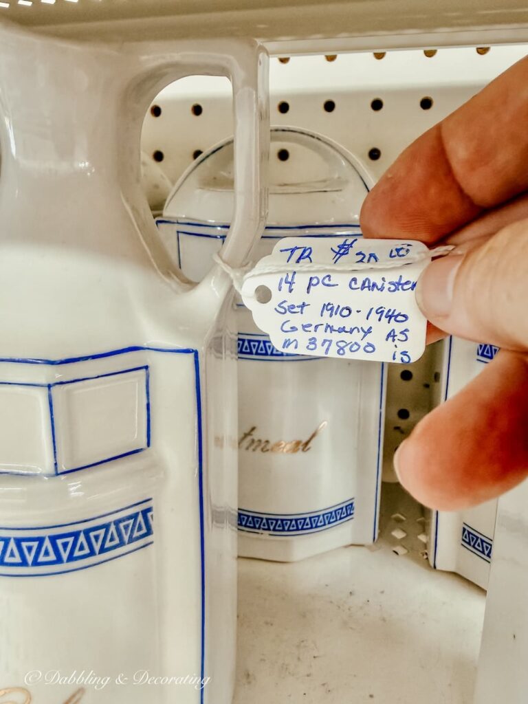 price tag in hand on a ceramic white canister set antiquing in Maryland.