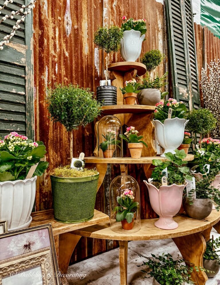 Pink and green spring gardening arrangements layered in a vintage booth at Vintage Market Days for Spring.