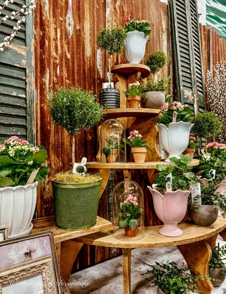Pink and green spring gardening arrangements layered in a vintage booth at Vintage Market Days for Spring.