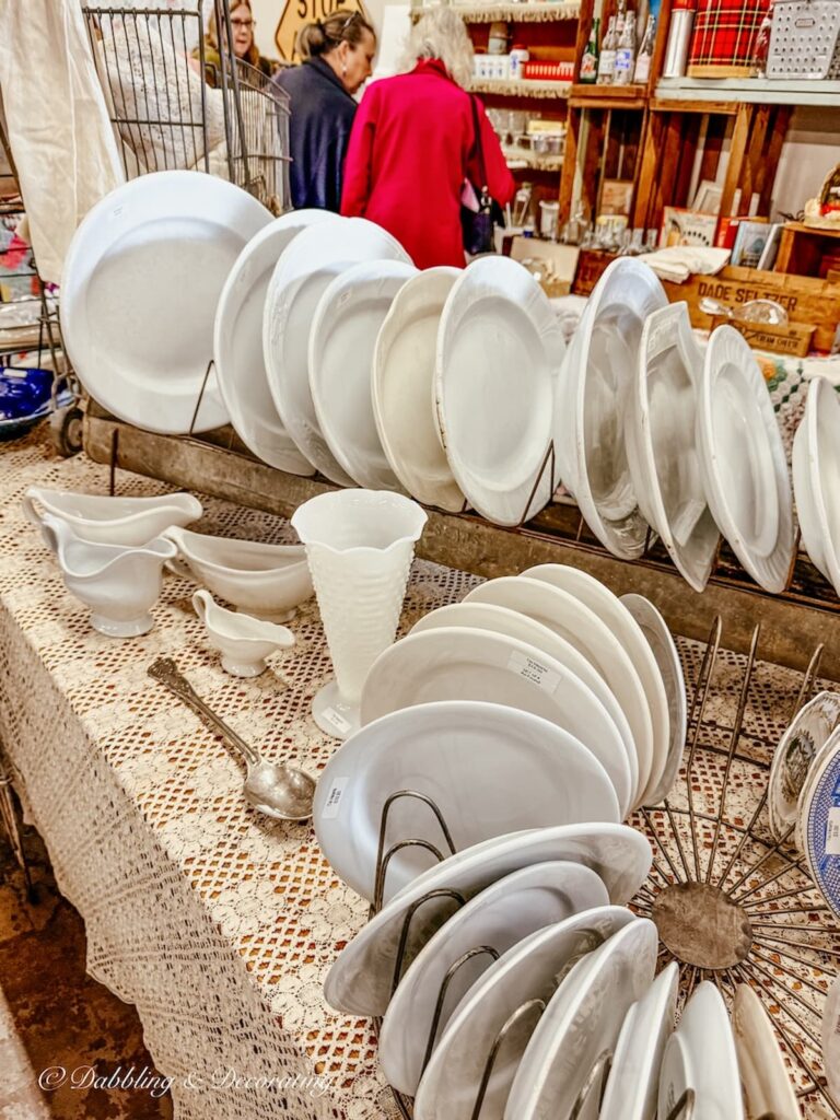 Ironstone dishes in vintage dish racks on display in volumes in vintage booth at Vintage Market Days.