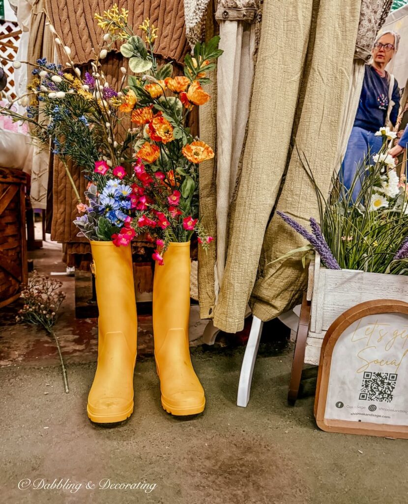 A pair of yellow wellies boots filled with spring flowers inside a vintage booth at Vintage Market Days.