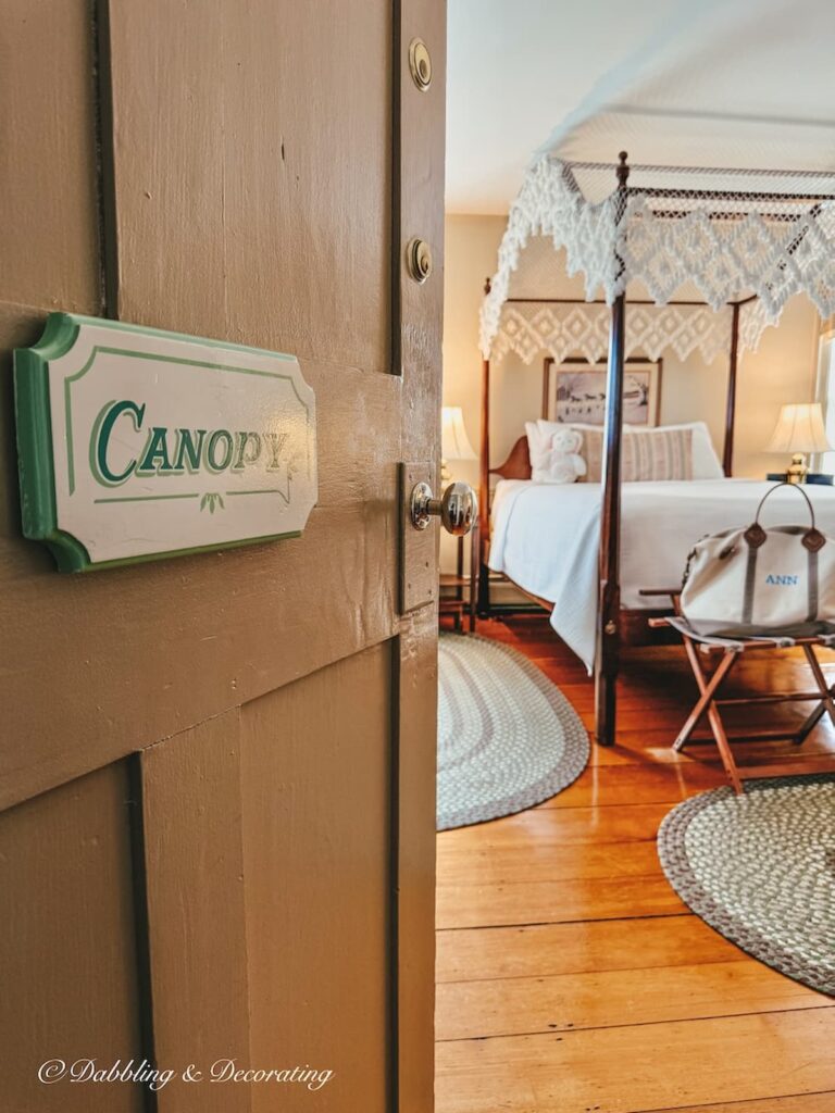 Canopy bed in bedroom at The Rabbit Hill Inn in Vermont with door open with Canopy sign after a solo day antiquing.