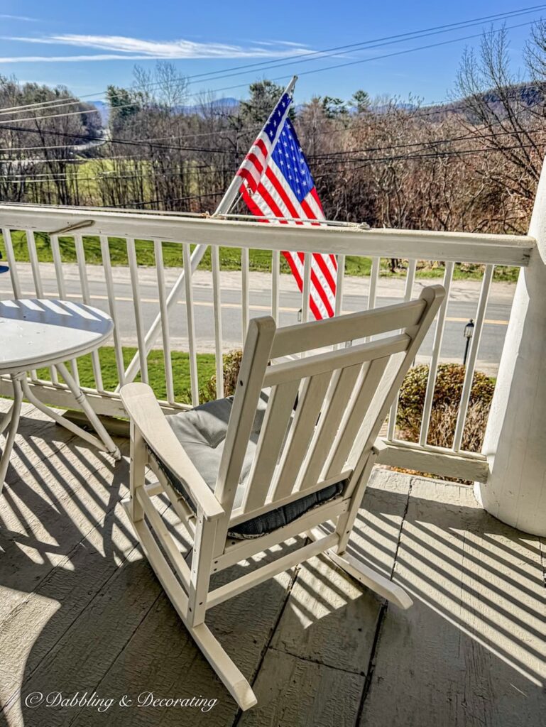 White rocking chair on porch overlooking mountains at the Rabbit Hill in Vermont.