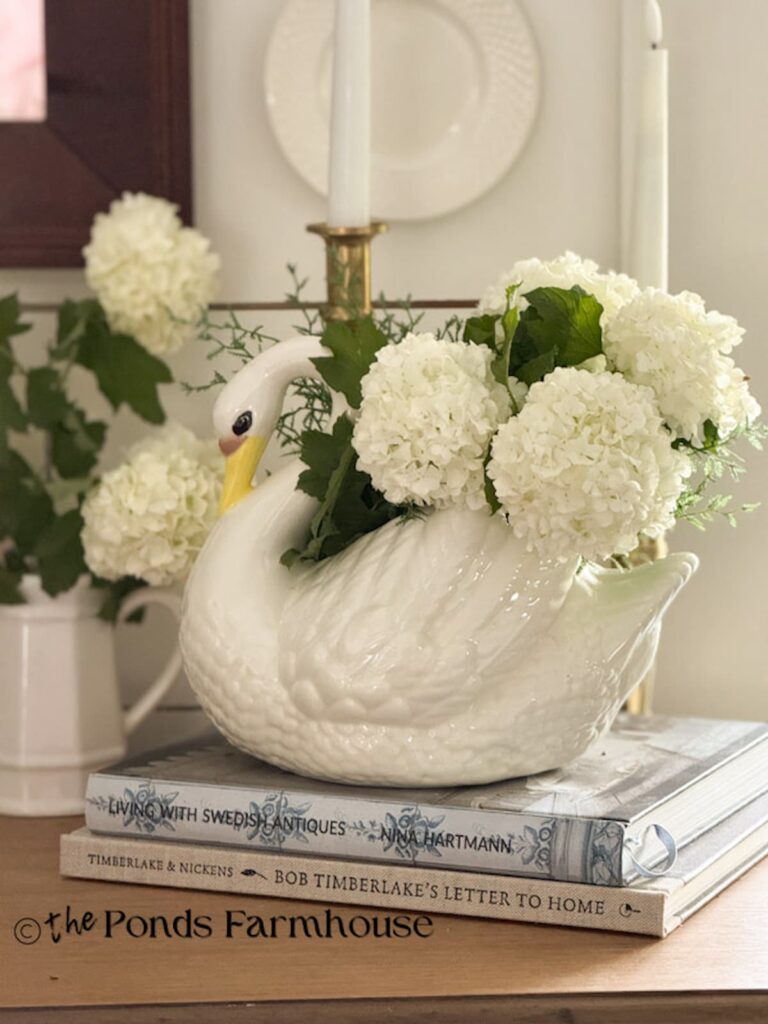 Vintage white swan filled with white hydrangeas.