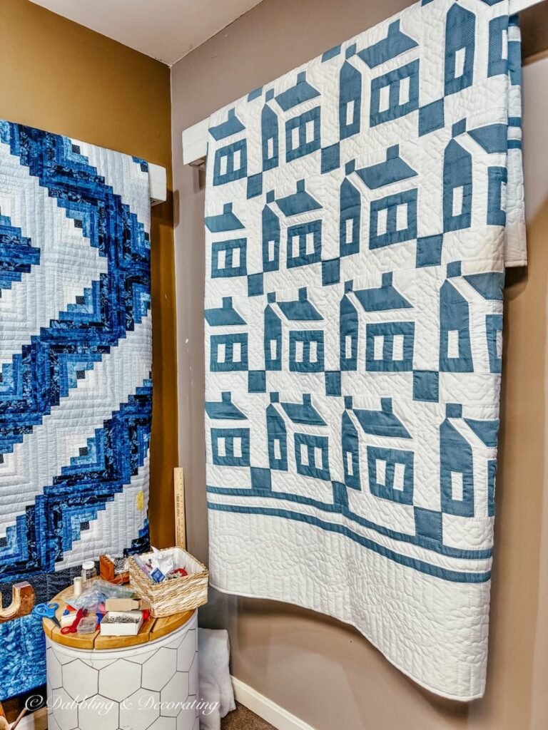 Handmade blue and white Amish quilt hanging on wall in shop with blue home's quilted in.