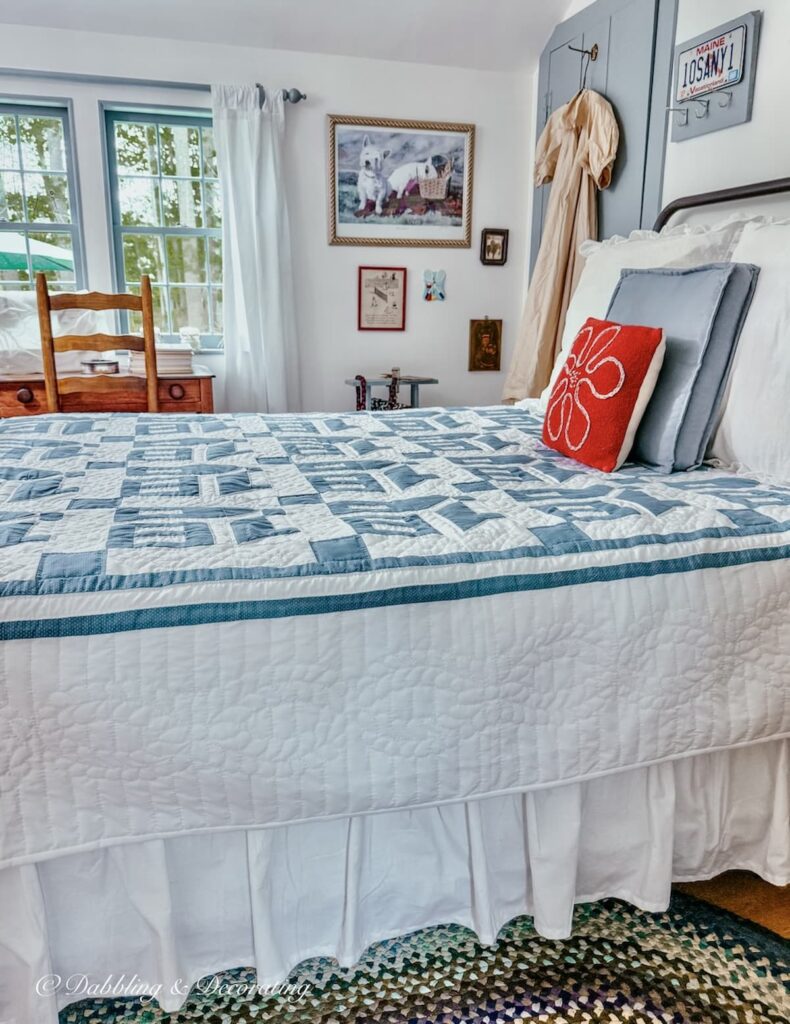 Blue and white Amish quilt on wrought iron bed in small guest bedroom at home in Maine.