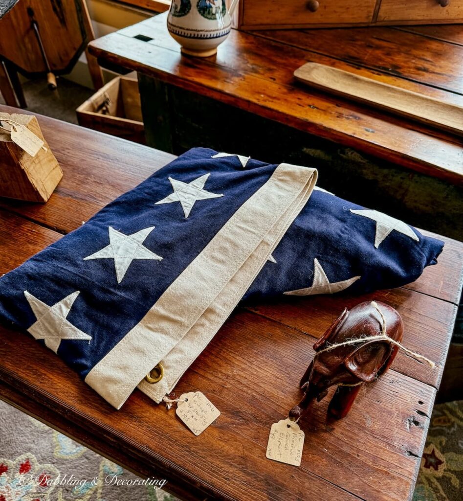 Antique USA flag folded up on antique table in antique store for heritage Americana decor ideas.