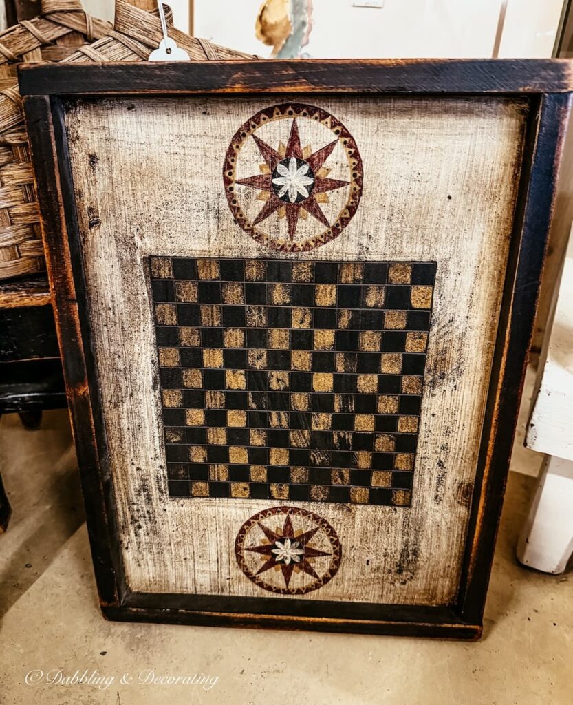 primitive style black, white, and red checker board in antique store, ideal for heritage Americana decor on a wall or table.