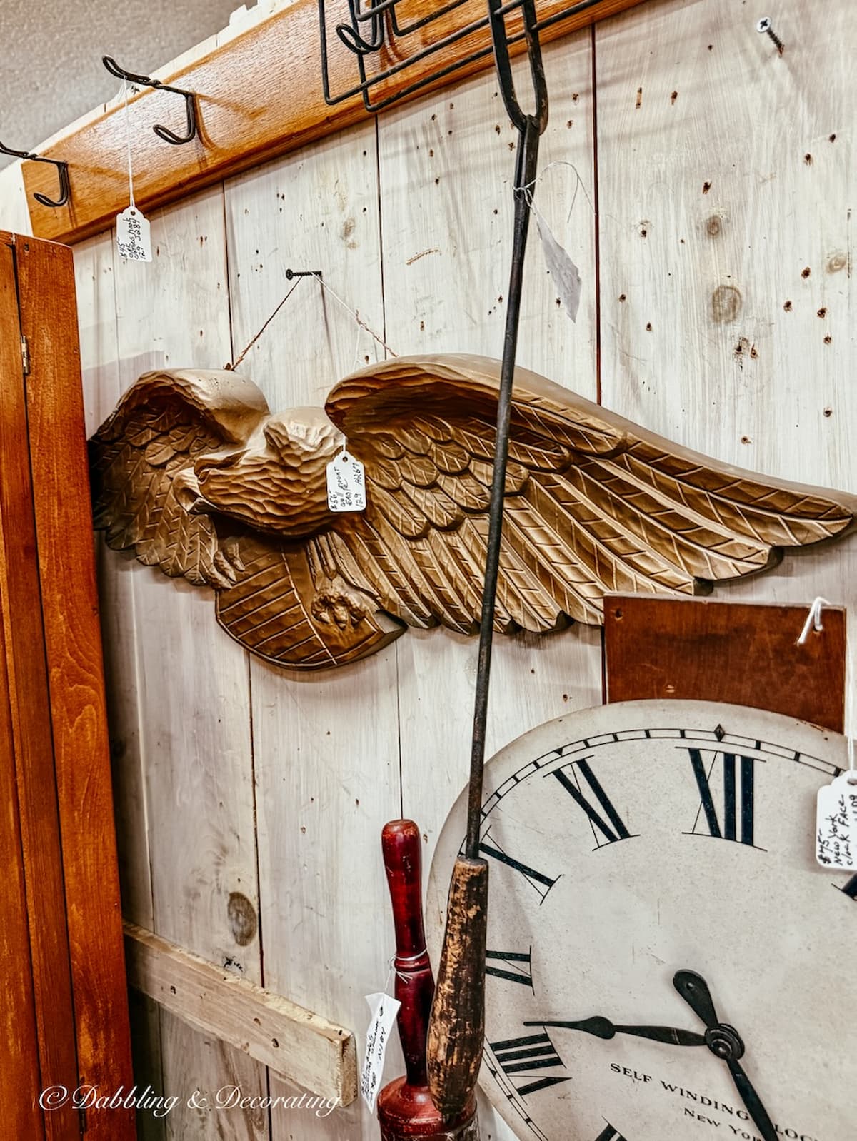 Large wooden Eagle on wall of vintage booth inside antique store for heritage Americana decor ideas.