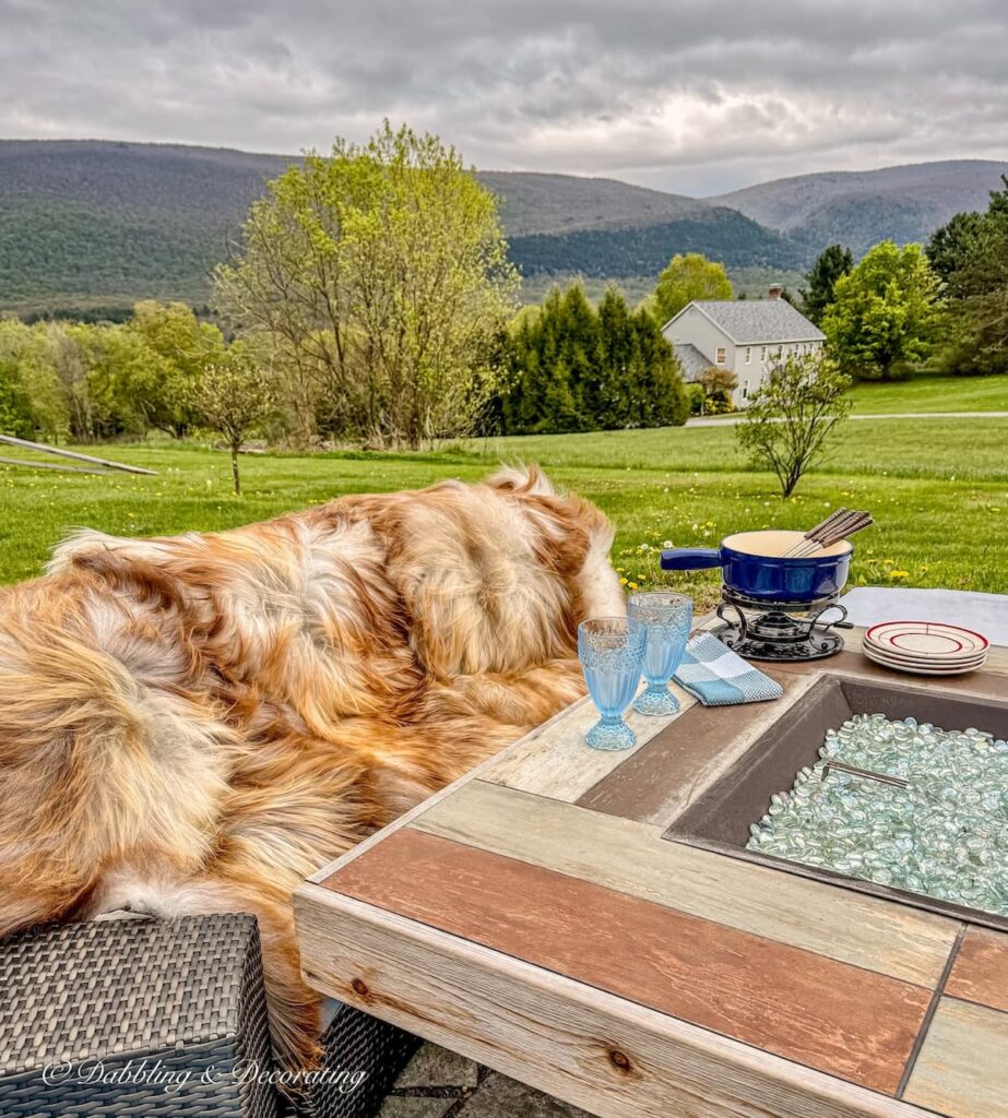 Outdoor fire pit seating with draped luxury sheepskins on seating with mountain views in Vermont.