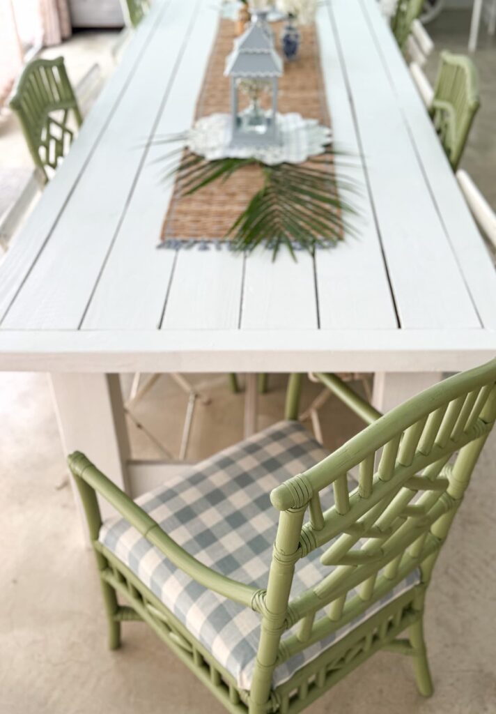 Green Serena & Lily chairs recovered at large white farmhouse table.