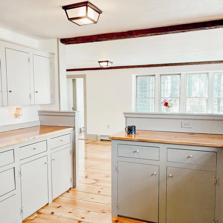 Old home kitchen with wooden countertops and cupboards and adjoining dining room trim newly painted with Nantucket Gray by Benjamin Moore with Simply White Walls.