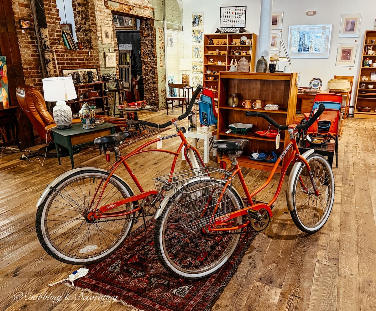 Two orange retro bicycles displayed in a vintage booth at the Open House Portland Antique store in Maine.