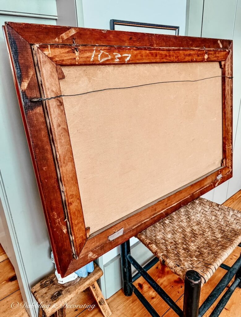 The back of an antique painting with canvas and one long wire to hang it with.
