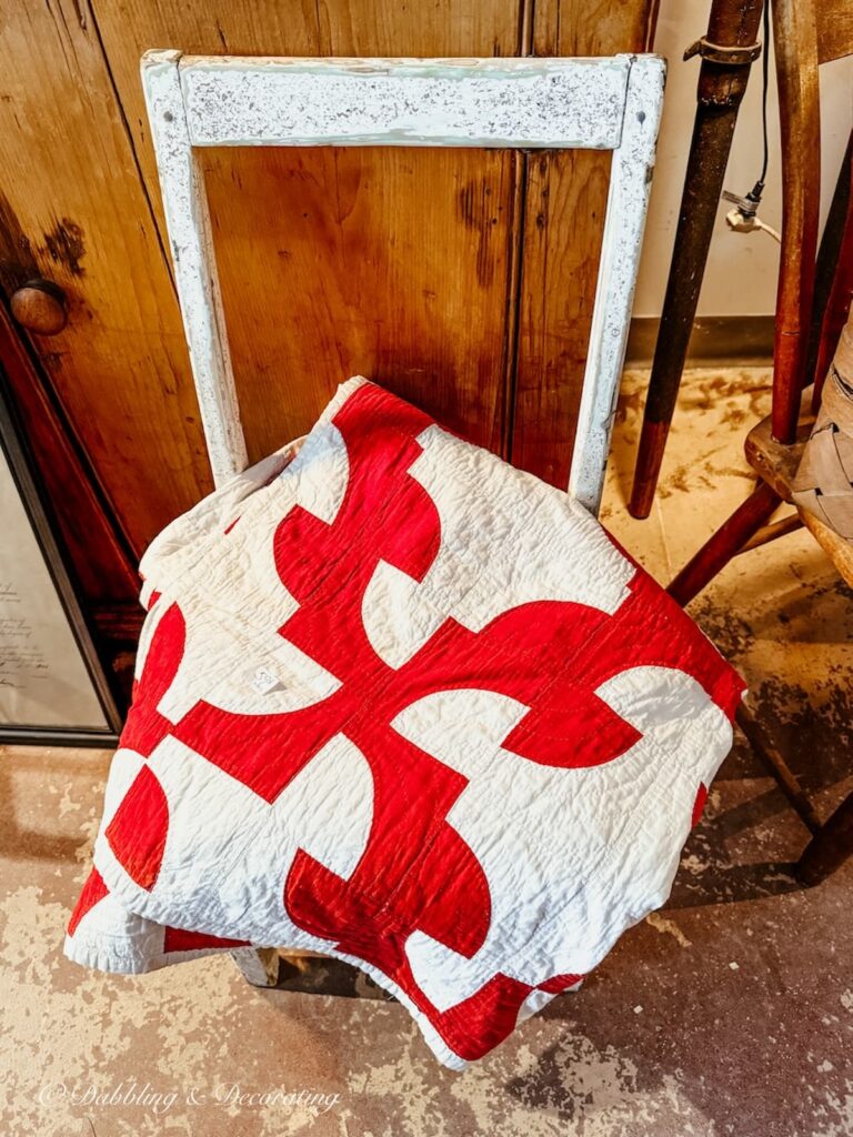 vintage red and white quilt in old chair in Sutton Quebec Antique Store.