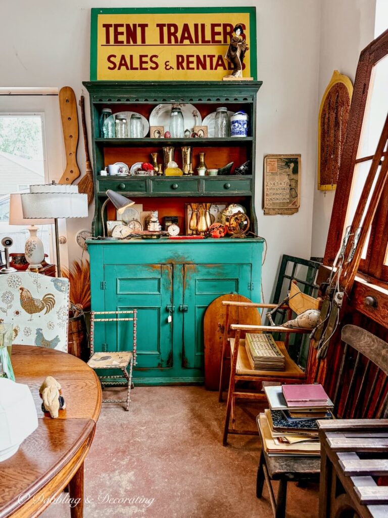 Large antique green cabinet with yellow sign inside antique store between Dunham and Sutton Quebec.